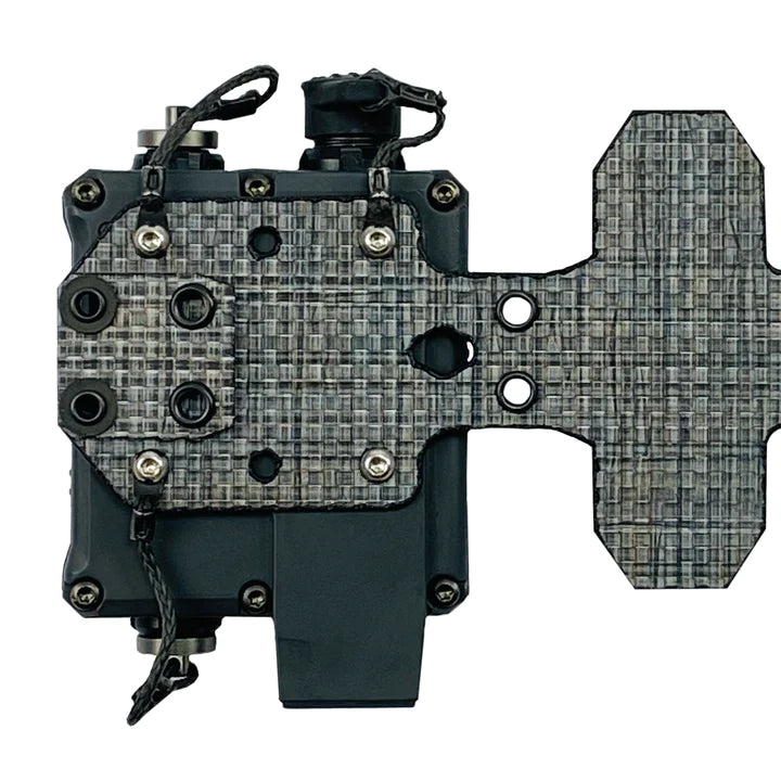 P/N: 14103-TBD: The CommSled mounts the PTT offset to the carrier and flexibly allows clearance of ATAK and similar systems, as well as lower profile mounting and improved access to PTT controls. Using shockcord, the CommSled pulls the PTT's outer edge into the plate carrier's intercostal space and keeps it spaced so that EUD devices can be used without interference by larger PTTs.